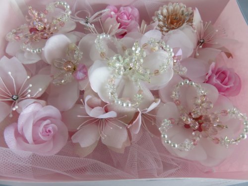 沢山の小花をふんだんに使用した、上品で手の込んだフラワーギフト商品です。  メインのお花の中心には、沢山のビーズによるお花飾り．桜．薔薇小花．ちりめんマーガレットをあしらいました。 また、桜の小花の中心にはダイヤパーツを付け、キラキラと光り輝くデザインに仕上げました。  オーガンジーとサテン地による豪華なお花のギフト、贈り物．お祝いに．お誕生日．母の日プレゼントに最適です。 お正月のプレセント．クリスマスプレゼントに喜ばれます。